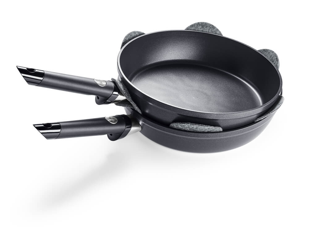 Two premium Fissler pans with Non-Stick Coating, stacked with the Fissler pan protector for German quality and innovative protection.