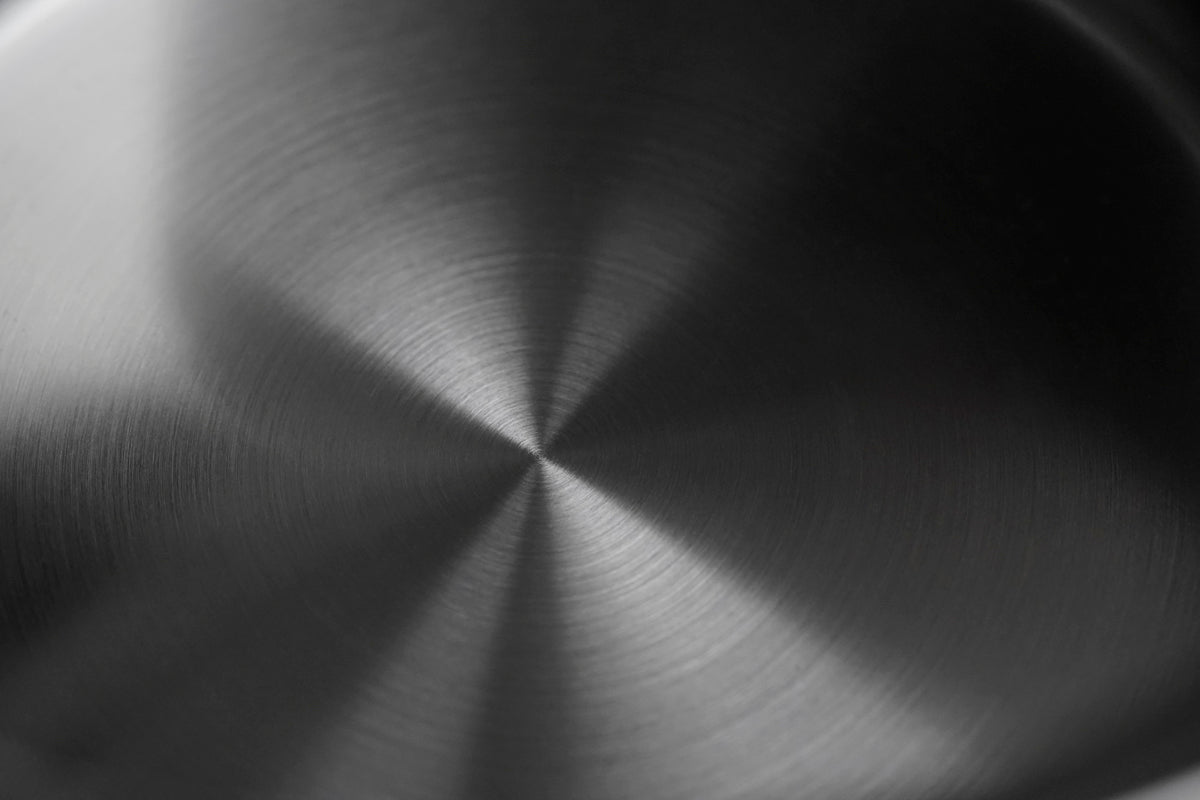 Detailansicht einer gebürsteten Edelstahloberfläche der Fissler Phi Collection® Stielkasserolle – präzise in Deutschland gefertigt.