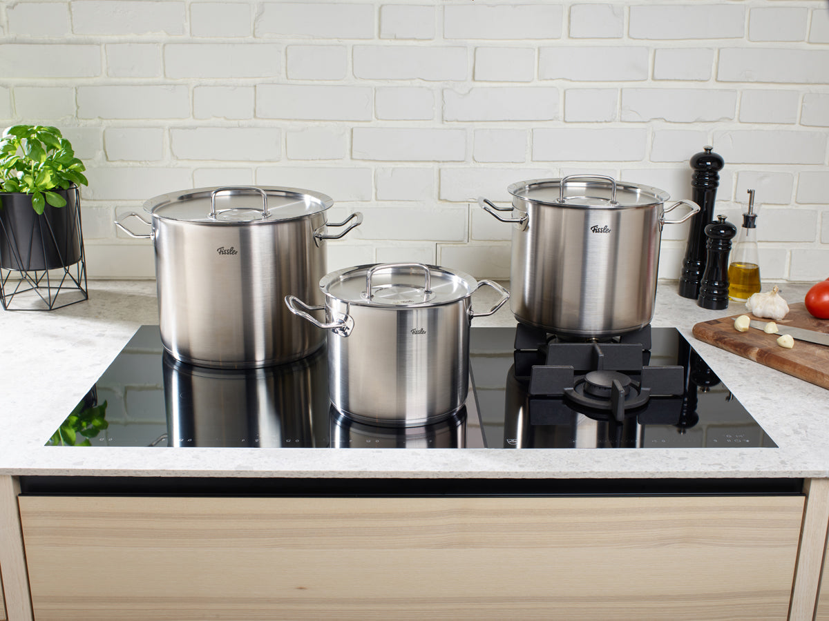 Three Fissler Original-Profi Collection® stainless steel Cooking Pots with Lid on stove; modern, durable, precision-made.
