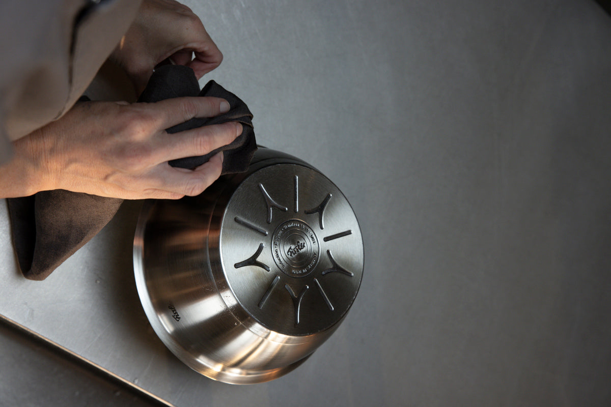 Die in Deutschland gefertigte Fissler Original-Profi Collection® Sauteuse 20 cm wird auf dem Kopf stehend auf einer glatten Metalloberfläche poliert.