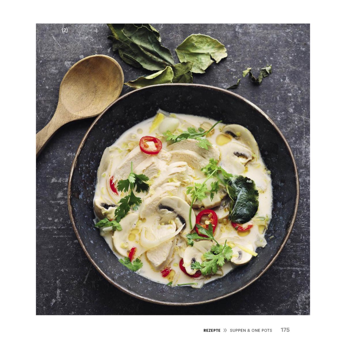 Creamy chicken soup with mushrooms, chili, and herbs on a dark plate - efficiently prepared with a Fissler pressure cooker.