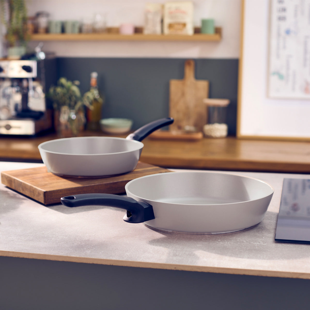 Fissler Ceratal® Evo Comfort pans (24 cm & 28 cm) with black handles display German precision and durability on a kitchen counter.
