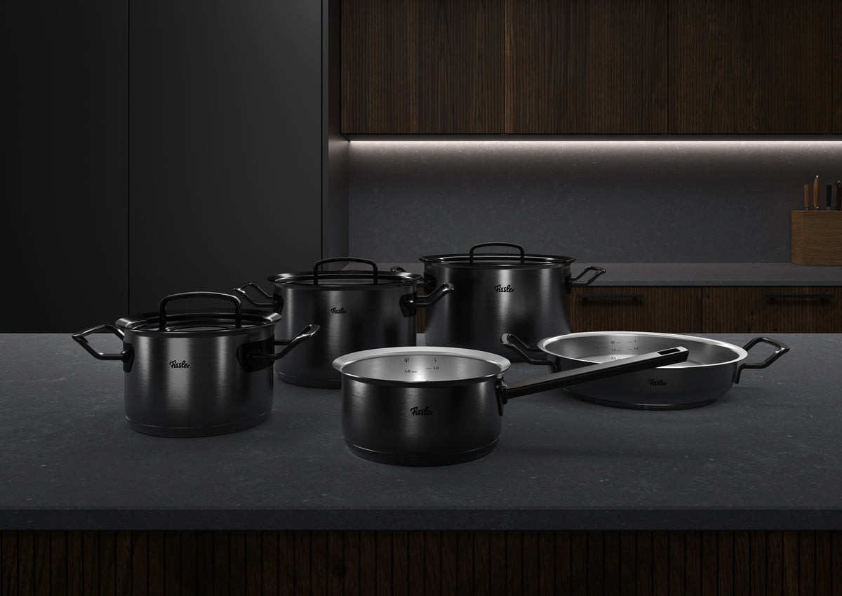 5-piece Fissler Original-Profi Collection® Shadowline set made of stainless steel, made in Germany, on an elegant counter with wood accents.