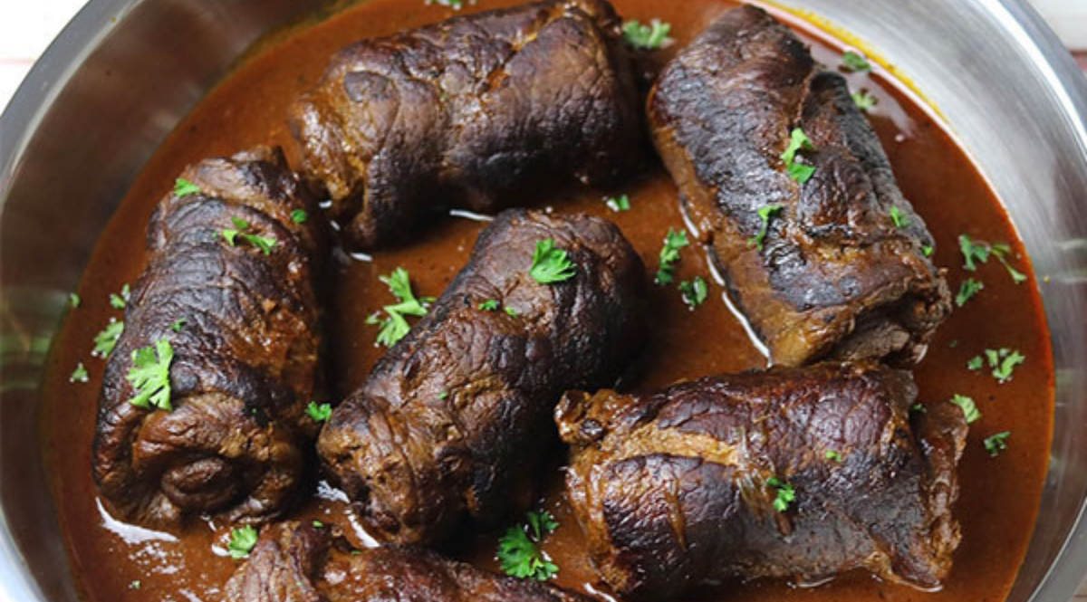 Geschmorte Rinderrouladen in reichhaltiger Sauce, garniert mit Petersilie, elegant serviert in einer Fissler-Edelstahlpfanne.