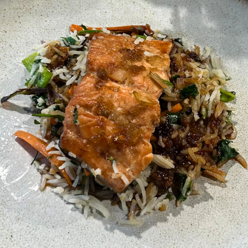 Perfectly pan-seared salmon on fried vegetable rice, artfully arranged - a testament to the timeless precision and quality of Fissler cookware.