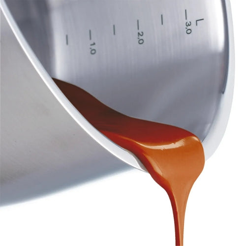 Die Karamellsauce fließt aus einer Fissler-Rührschüssel aus rostfreiem Stahl, die mit eingravierten Volumenangaben versehen ist.