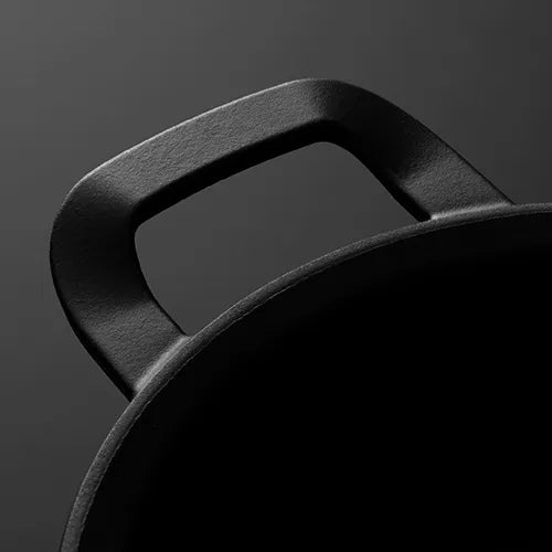 Nahaufnahme eines gusseisernen Topfgriffs von Fissler, der vor einem dunklen Hintergrund präzisionsgefertigtes Design und langlebige deutsche Qualität demonstriert.