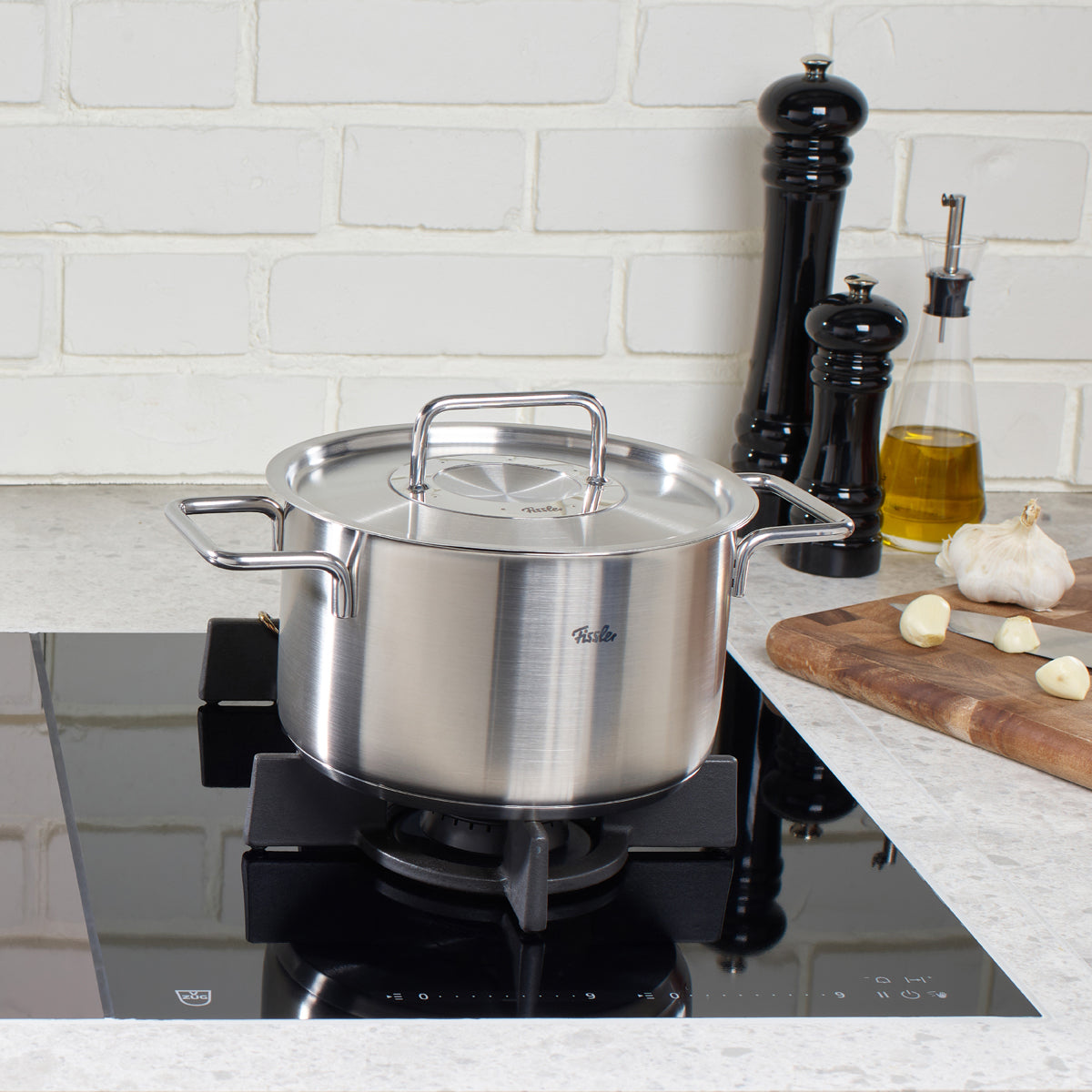 Fissler Pure Collection Kochtopf auf Induktionskochfeld, Marmorarbeitsplatte. Edelstahl, Made in Germany. Zeitloses Design.