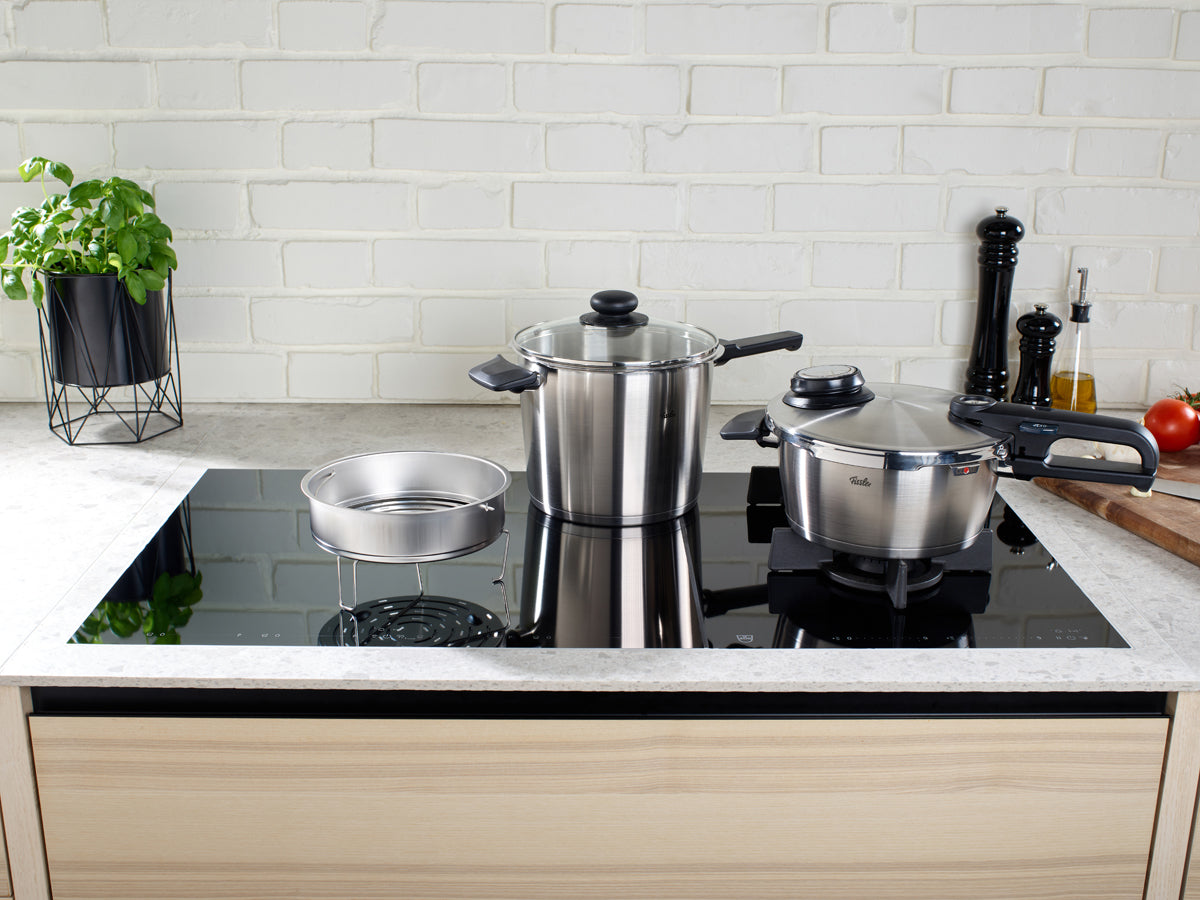 A modern kitchen showcases the Fissler Vitavit® Premium pressure cooker set, crafted in Germany from stainless steel since 1845.