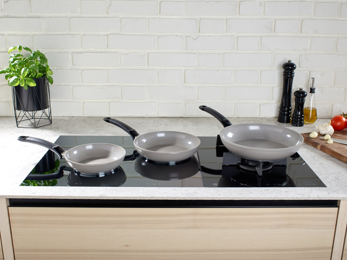 Fissler Ceratal® Classic Pfannen mit PTFE-freier Keramikbeschichtung auf dem Induktionskochfeld, die deutsche Präzision und Design zeigen.
