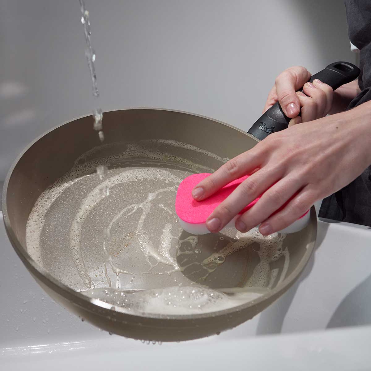 Die Reinigung der Fissler Ceratal® Comfort Pfanne 26cm mit Glasdeckel unter fließendem Wasser unterstreicht ihr pflegeleichtes, hochwertiges Design.